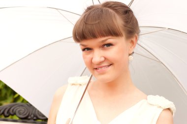 Beautiful young woman under white umbrella clipart