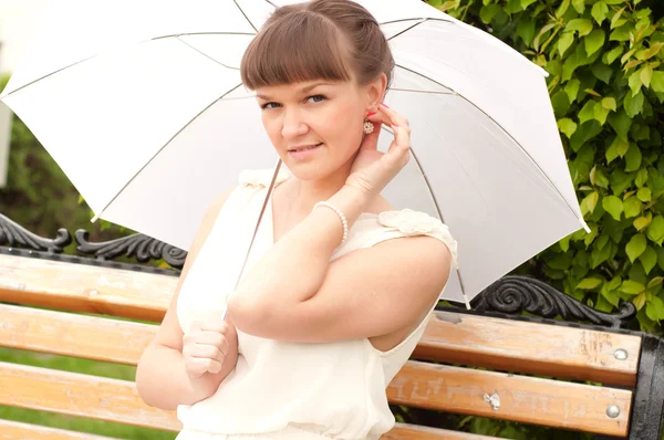 Beautiful young woman under white umbrella — Stock Photo, Image