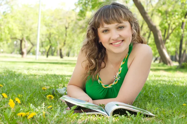 Woman in a park reading a magazine Royalty Free Stock Images