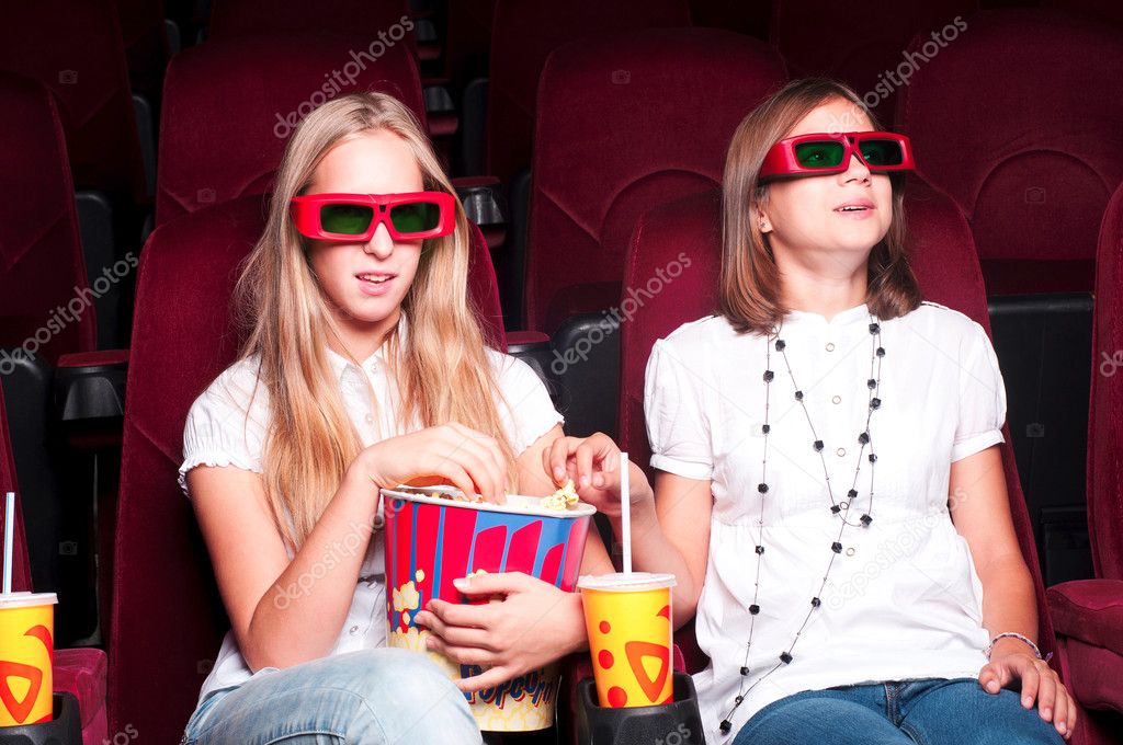 Two girls watching a movie at the cinema