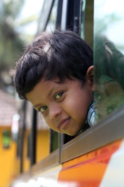 Handsome and cute little indian school kid looking back with hap clipart