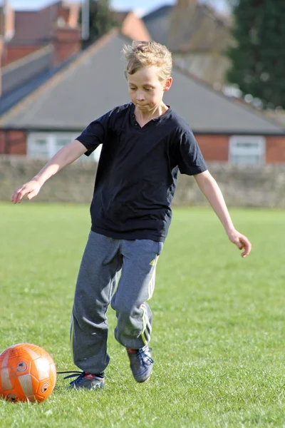 Мальчик-подросток играет в футбол — стоковое фото