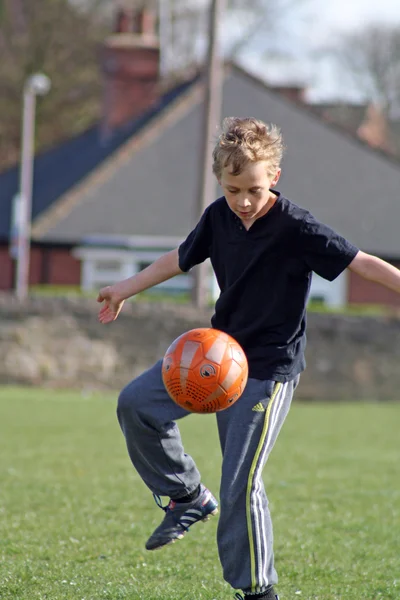 Tonårspojke spela fotboll — Stockfoto