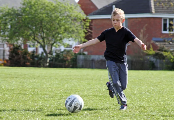 Tonårspojke spela fotboll — Stockfoto