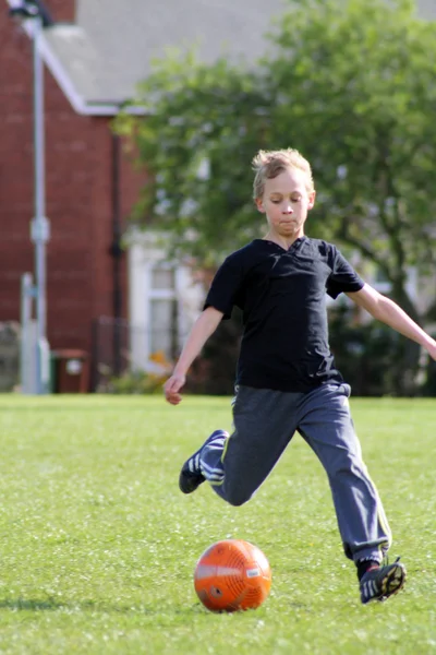 Futbol oynayan genç çocuk — Stok fotoğraf