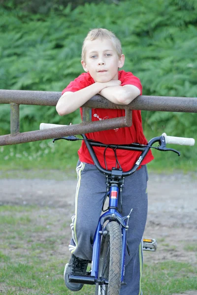 Хлопчик-підліток в парку зі своїм велосипедом — стокове фото