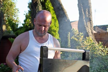 Man cooking at the bbq clipart