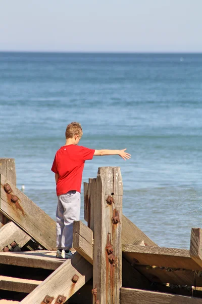 Teenage boy looking out to sea — Stock Photo, Image