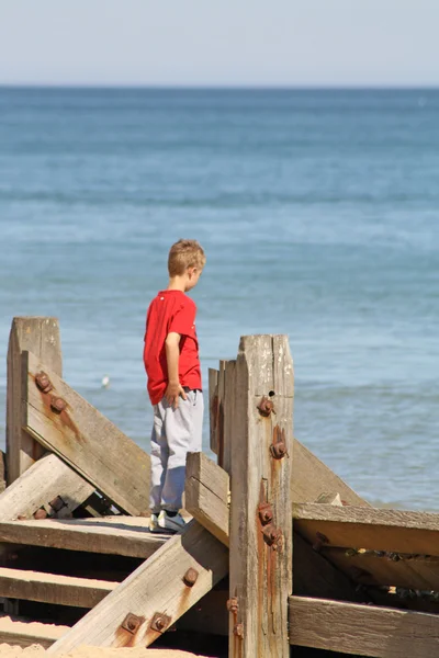 Teenage boy looking out the sea — Stock Photo, Image