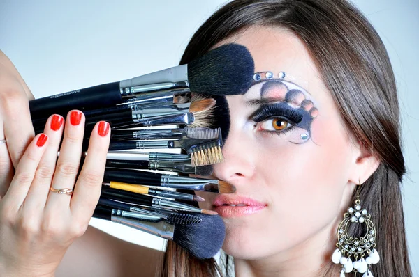 Retrato de una mujer hermosa con pinceles de maquillaje — Foto de Stock