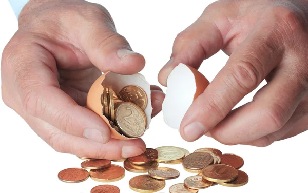 Monedas en cáscara de huevo rota, en mano —  Fotos de Stock