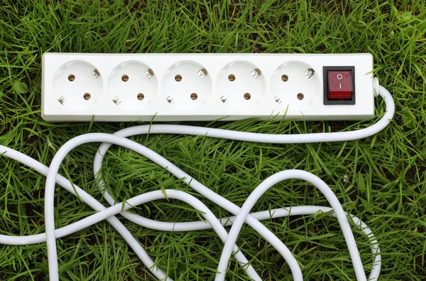 An power strip lying on the grass — Stock Photo, Image