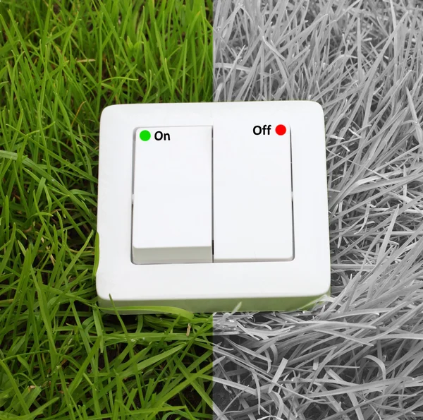 Light switch on a green grass background — Stockfoto
