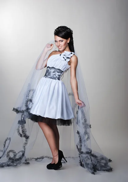 Schöne Braut steht im Hochzeitskleid — Stockfoto