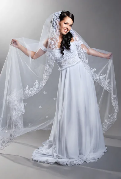 Krásná nevěsta stojí ve svatebních šatech — Stock fotografie