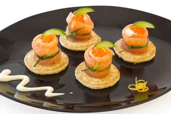 Rolos de salmão vermelho com queijo, caviar e pepino em "blinis" — Fotografia de Stock