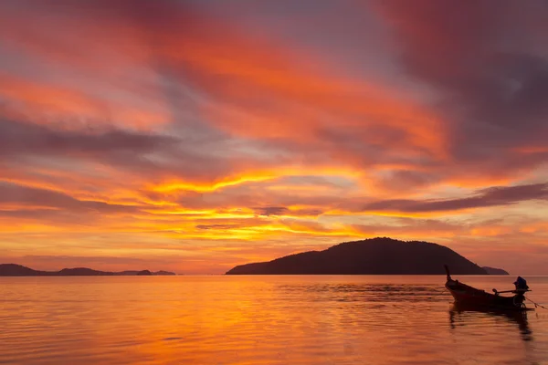 stock image Vivid color sunrise in Phuket, Thailand, with far island and a fishing boat silhouette