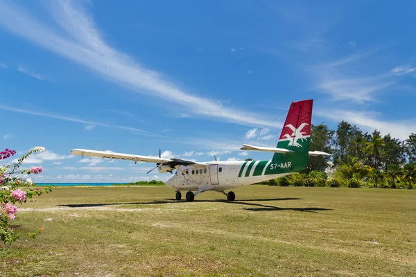 Pequeño avión tropical doméstico, acaba de aterrizar en el campo de hierba — Foto de Stock