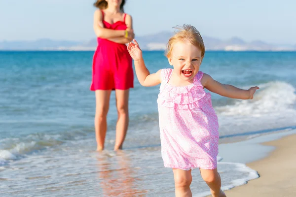 Klein meisje loopt op het strand — Stockfoto