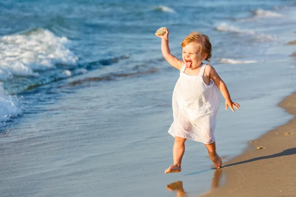 Маленькая девочка играет на пляже — стоковое фото