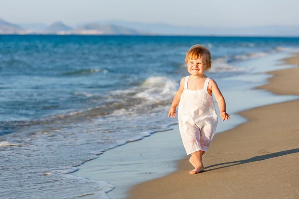 Malá holka kráčí po pláži — Stock fotografie