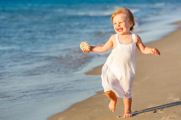 Маленька дівчинка біжить на пляжі — стокове фото