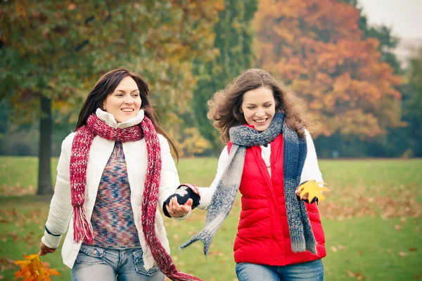 Twee jonge vrouw wandelen in herfst park — Stockfoto