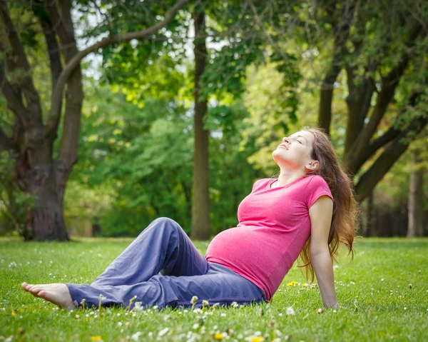 Krásná těhotná žena v parku — Stock fotografie