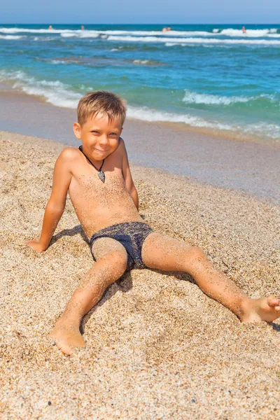 Boy on the beach with sea on background — Stock Photo, Image