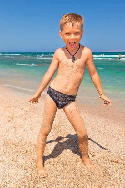 เด็กชายบนชายหาดที่มีทะเลบนพื้นหลัง — ภาพถ่ายสต็อก