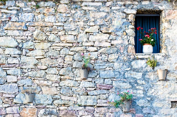 Mediterranean stone facade with window and flowers — Stock Photo, Image
