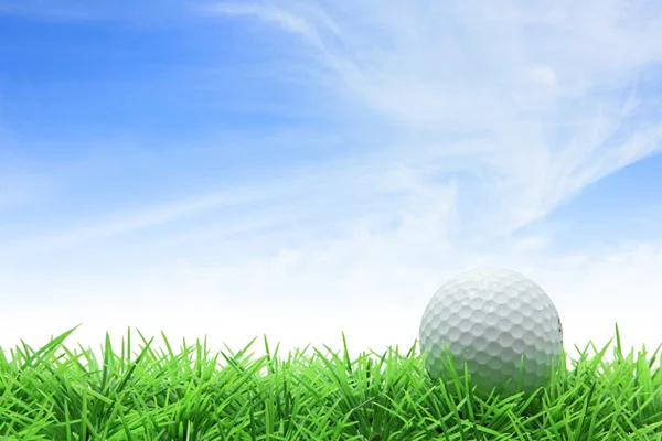 Гольф мяч на зеленой траве против голубого неба — стоковое фото