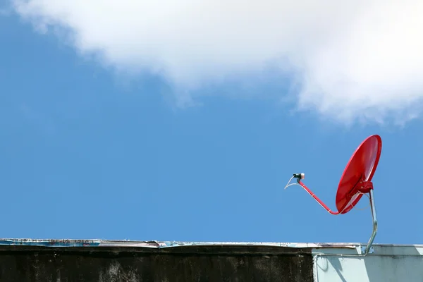 Изолированный красный спутник на солнечном голубом небе — стоковое фото