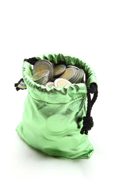 Κέρμα πλούτου σε πράσινο χρήματα τσάντα που απομονώνονται σε λευκό — Φωτογραφία Αρχείου
