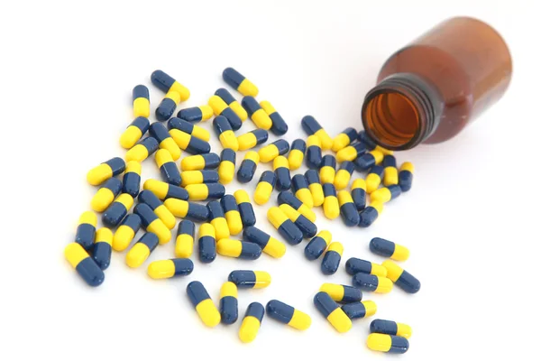 Perspective of Open pill bottle with capsule spilling out of it — Stock Photo, Image