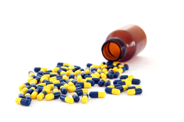 Isolated capsules spilling out — Stock Photo, Image