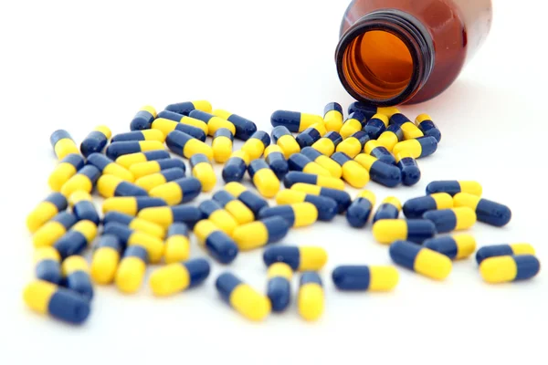 Perspective of isolated capsules spilling out — Stock Photo, Image