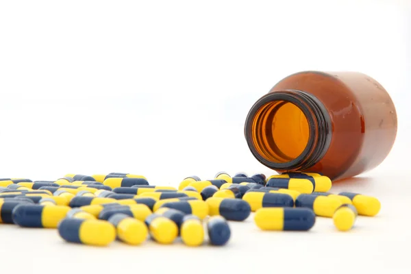 Close-up van geïsoleerde capsules morsen uit — Stockfoto