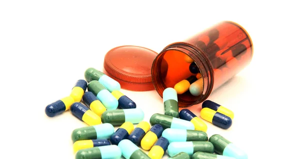 Colorful capsule spilling out from pill box — Stock Photo, Image