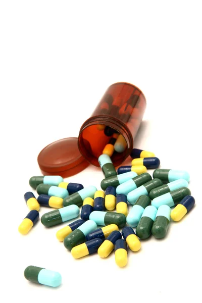 Kleurrijke capsule morsen uit uit pil fles — Stockfoto