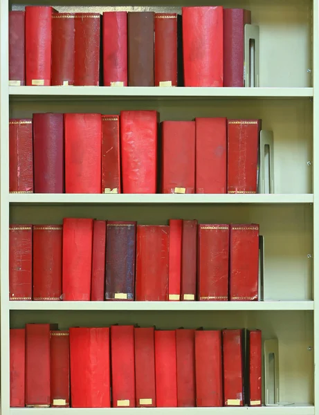 Красные старые книги в твердой обложке на книжных полках — стоковое фото