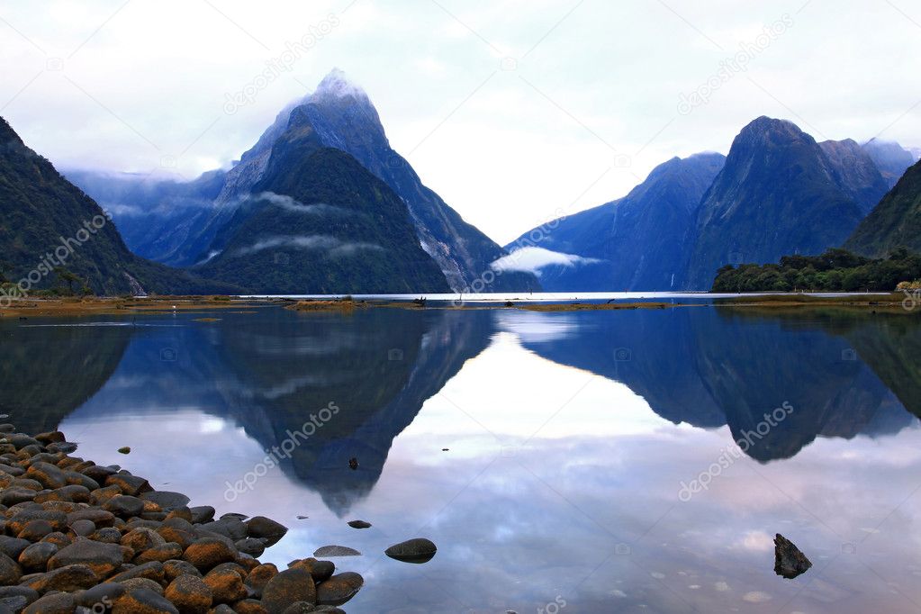Reflection of high mountain glacier at milford sound, New Zealan