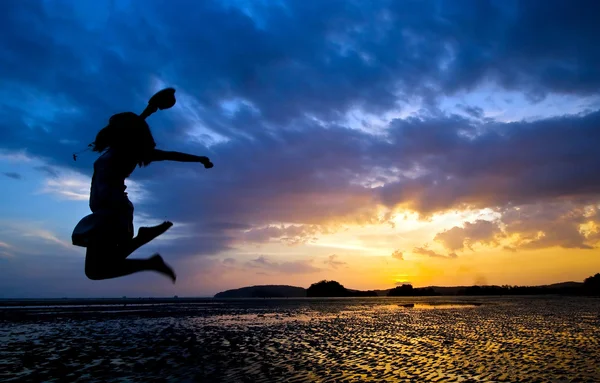 Jumper bij strand zonsondergang — Stockfoto