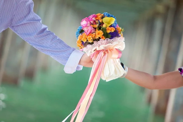Mão segurando lindo buquê de flores — Fotografia de Stock