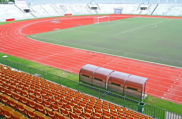 Treinador e bancos de reserva com assentos amarelos no estádio de futebol — Fotografia de Stock