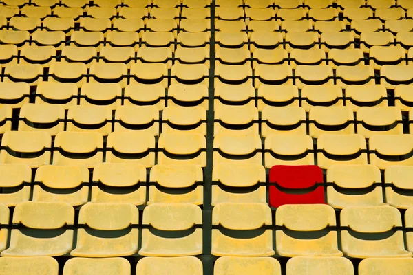 Roter Sitz in gelbem Sitzmuster im Fußballstadion — Stockfoto