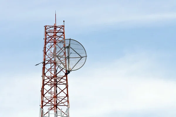Спутниковая тарелка на телекоммуникационной радиоантенной башне — стоковое фото