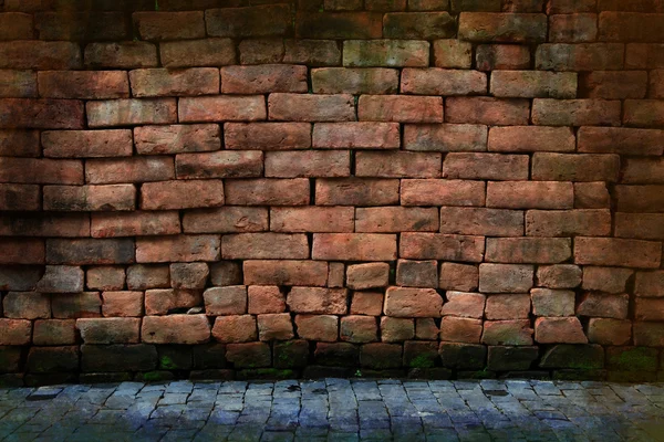 Dirty grunge red stone brick wall with pavement — Stockfoto