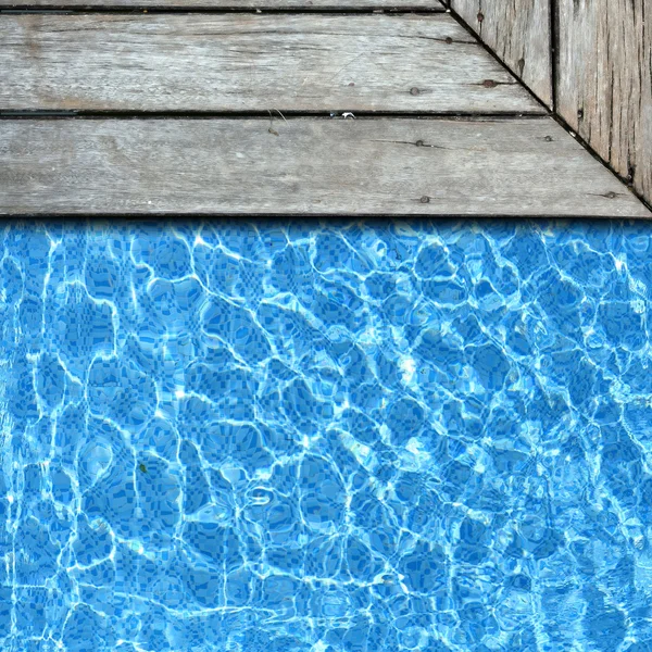 Pavimento de madeira com fundo borda da piscina — Fotografia de Stock