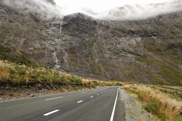 Gama de montanhas com cachoeira ao longo da estrada Milford Sound, fiordla — Fotografia de Stock